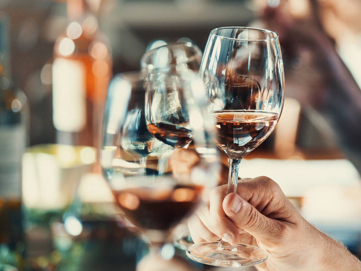a group of friends raising their wine glasses in a toast